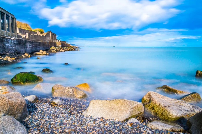 stone on ocean under white cloudy blue sky during daytime ireland 2k