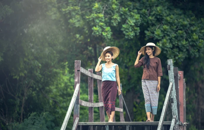 two women with hat walking on gray wooden bridge during daytime 2k 4k 5k