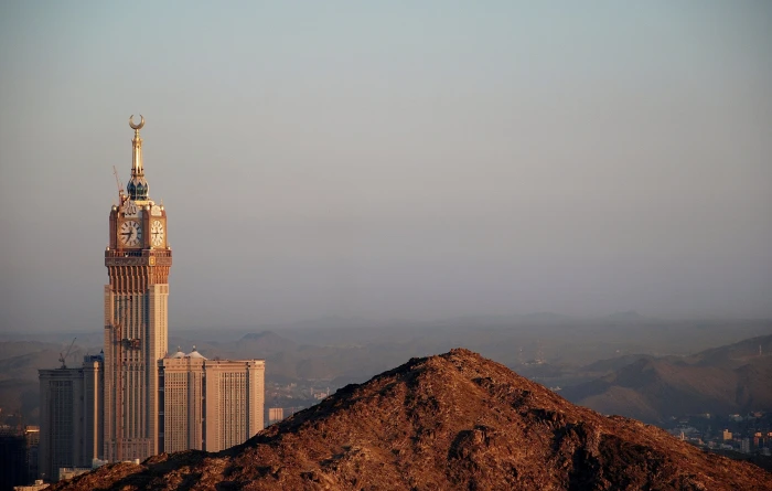 brown and gold tower clock surrounded with mountains mecca mekkah 2k 4k