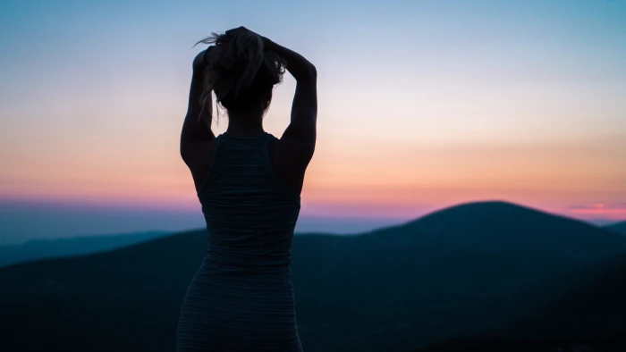 silhouette of woman standing near mountain peak facing with hands on head 2k 4k 5k