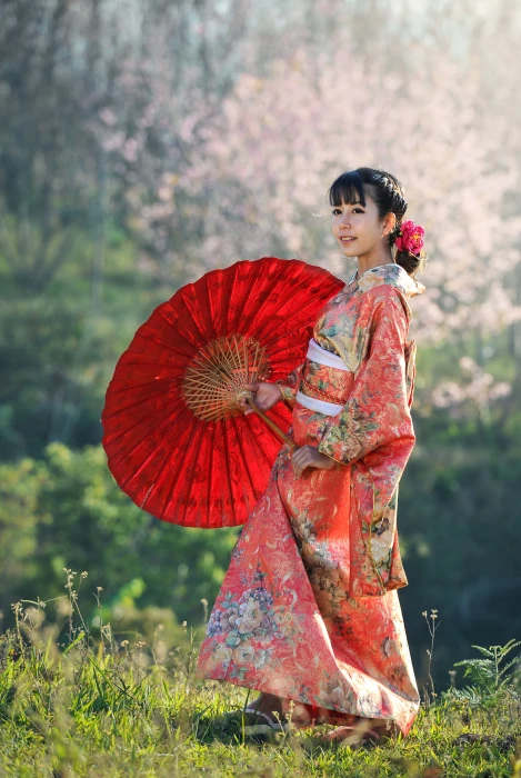 woman wears pink and multicolored floral dress holds red folding umbrella 2k