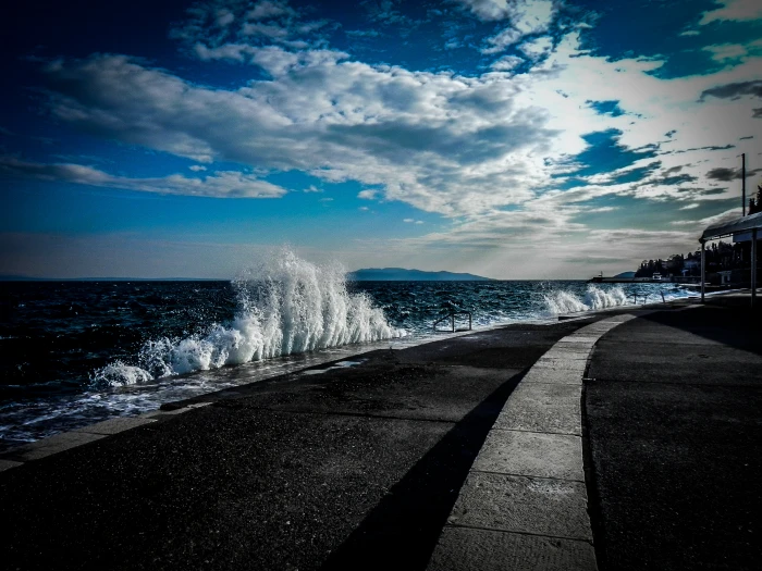 gray concrete road near the ocean water during daytime Waves 2k 4k