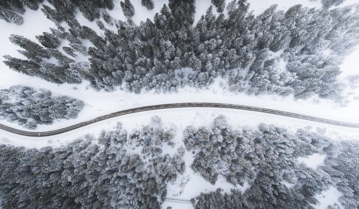aerial view of road surrounded by trees bird eye photography snow covered mountain 2k 4k