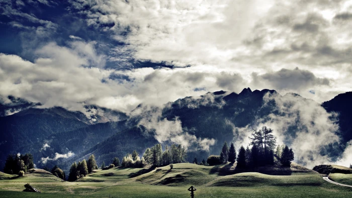green grass lawn with trees near mountain under blue and white cloudy sky 2k 4k 5k
