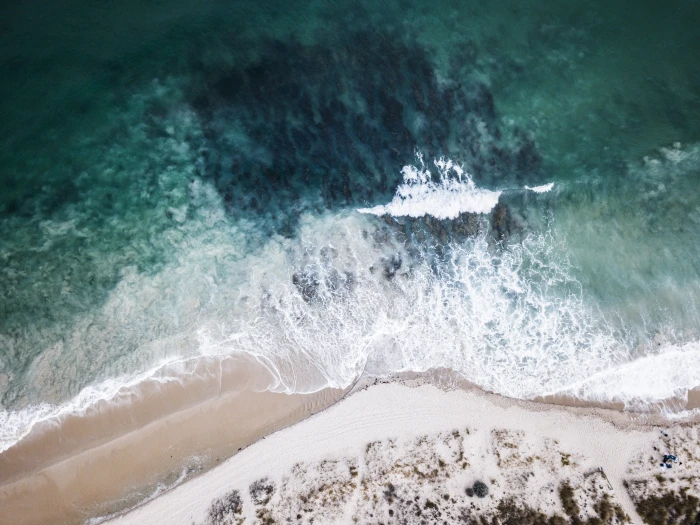 high angle photo of ocean waves crashing on shore sea white and brown 2k 4k