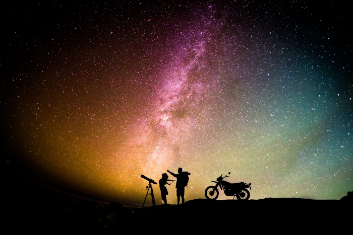 silhouette photo of man and woman standing between telescope with stand motorcycle 2k 4k 5k