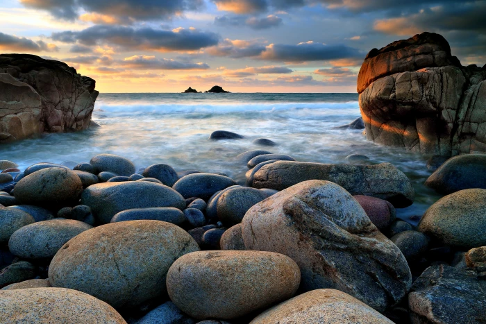 gray and brown stones beside body of water during sunset Porth Nanven 2k 4k 5k