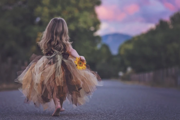 macro shot photography of girl in brown and black sleeveless gown holding sunflower during daytime 2k 4k