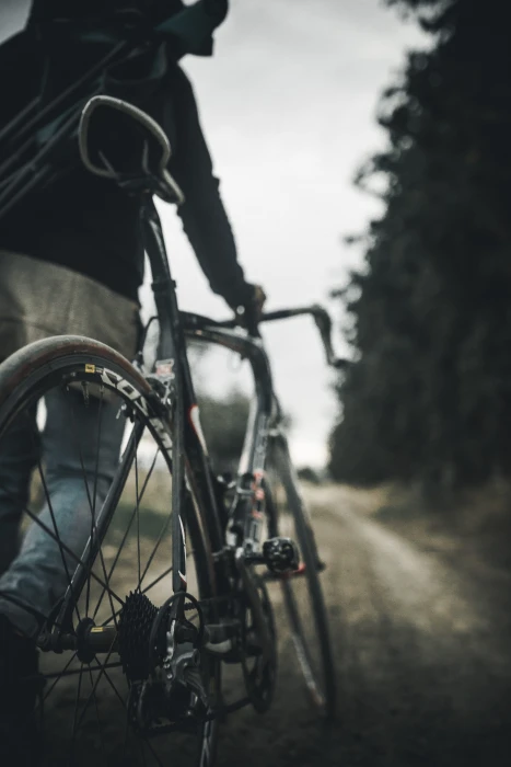 selective focus photography of person holding gray road bike on 2k 4k