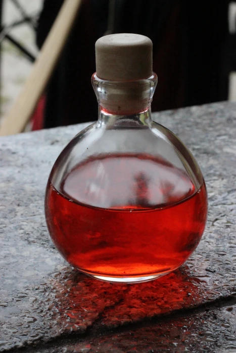 close up photo of clear glass bottle with red liquid potion 2k