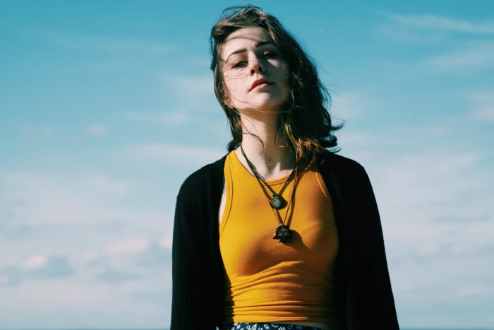 woman in black cardigan and brown tank top standing under blue sky 2k 4k 5k