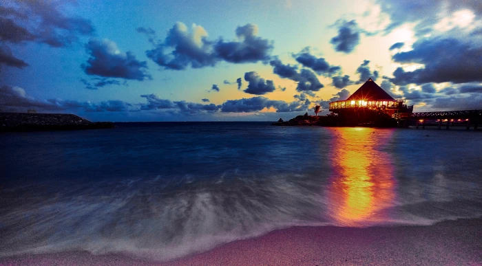 house beside sea shore against sunset rays under blue sky okinawa 2k 4k 5k