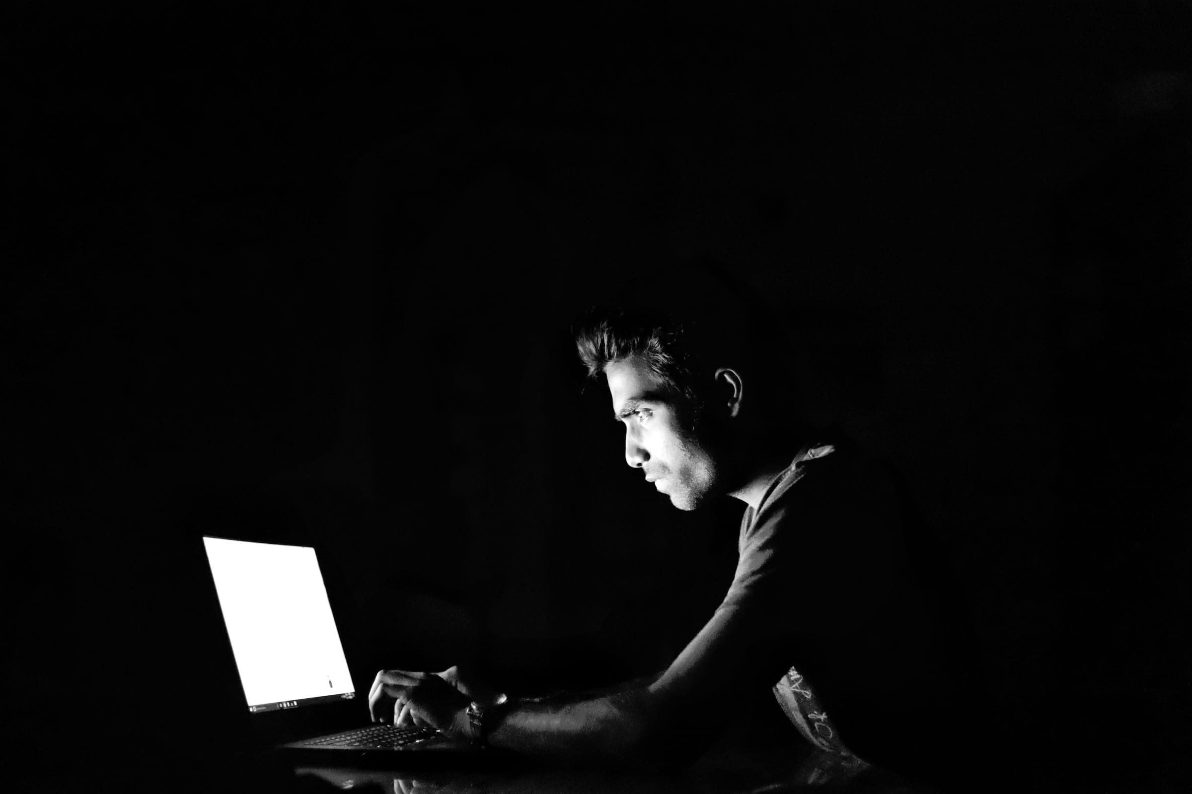 silhouette photography of man in front turned on laptop computer 2k