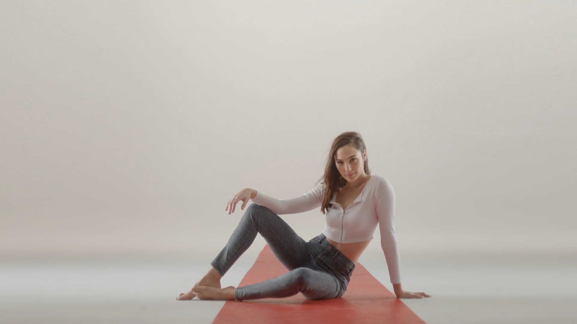 barefoot sitting actress simple background jeans brunette