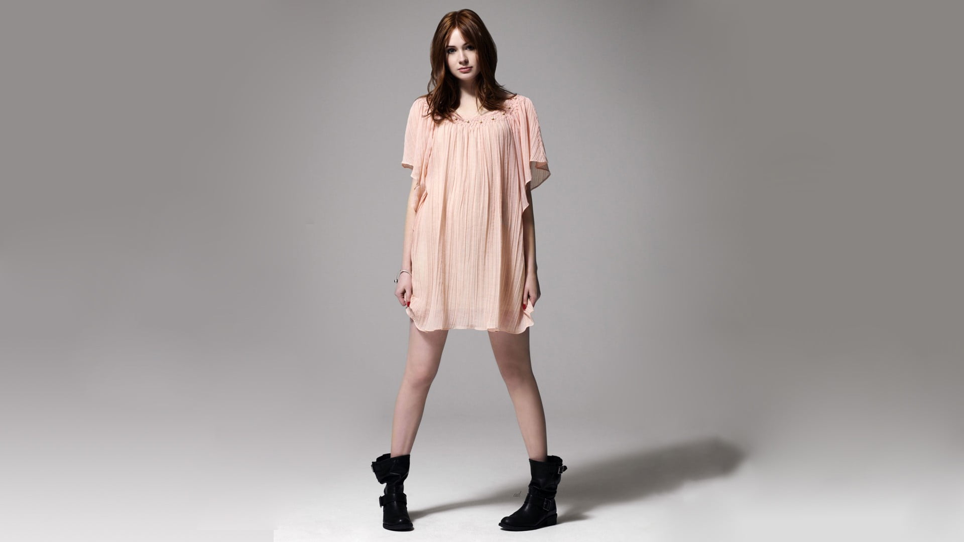 pair of women's black booties Karen Gillan actress boots gray background