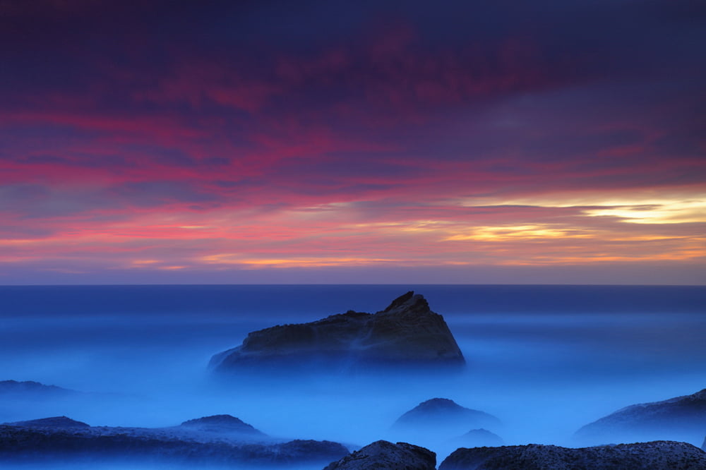 mountain range under red and yellow sky North Avalon Colour