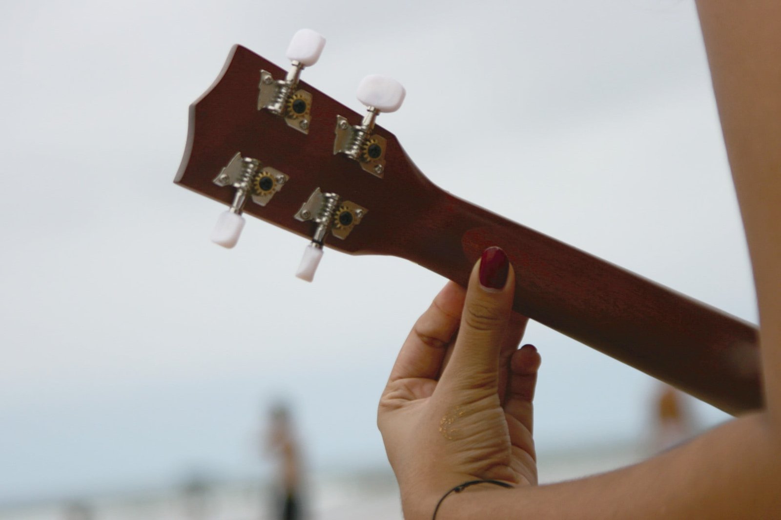 ukulele beach human hand body part focus on foreground 2k