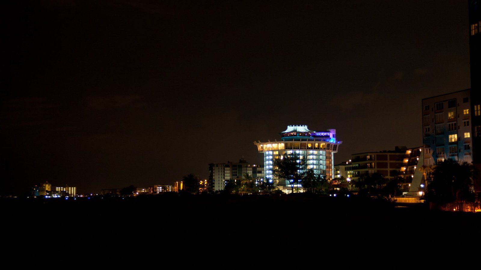 buildings lighted up at night lights beach illuminated architecture 2k