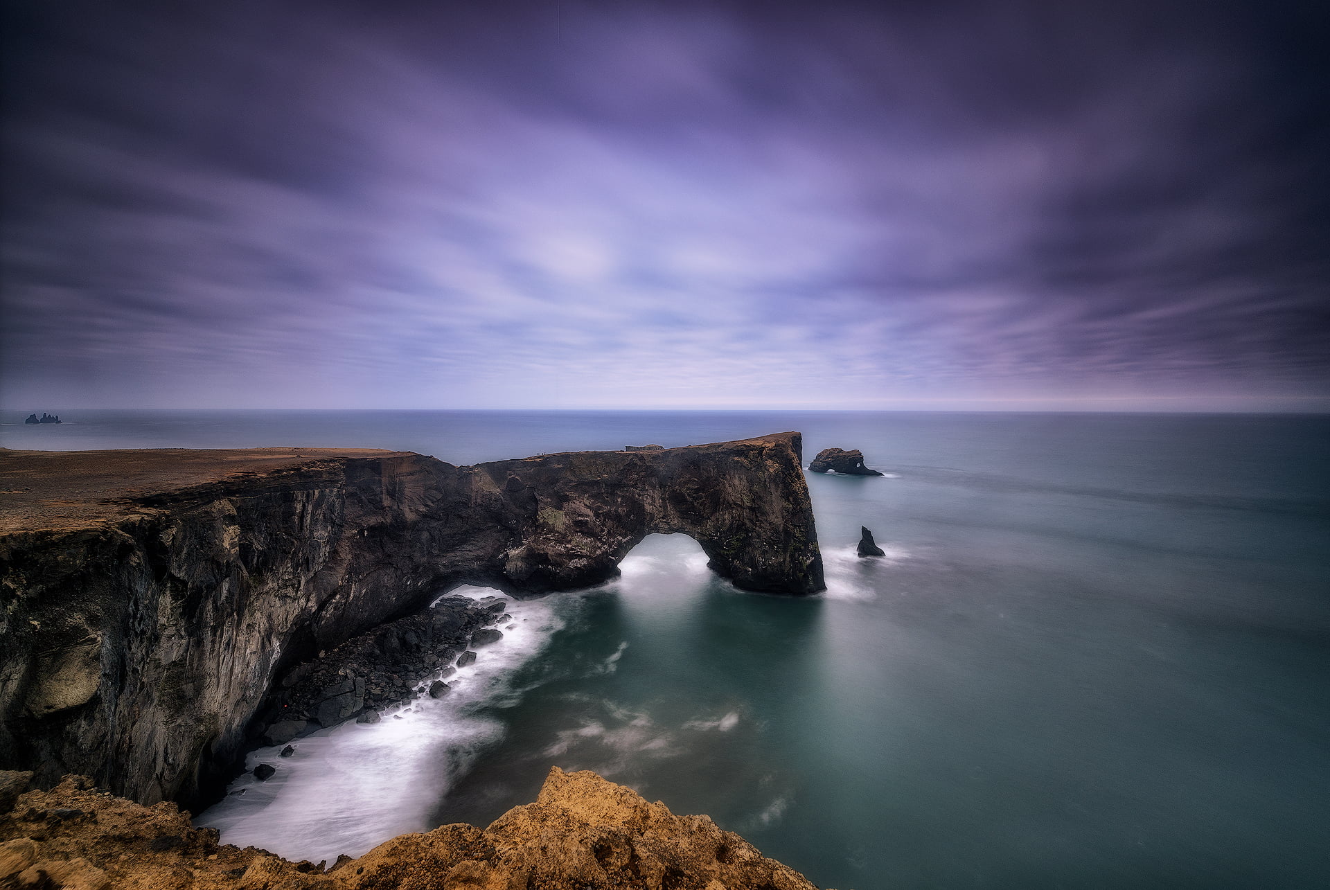black and brown rocks in ocean side during daytime arch Dyrh laey 2k