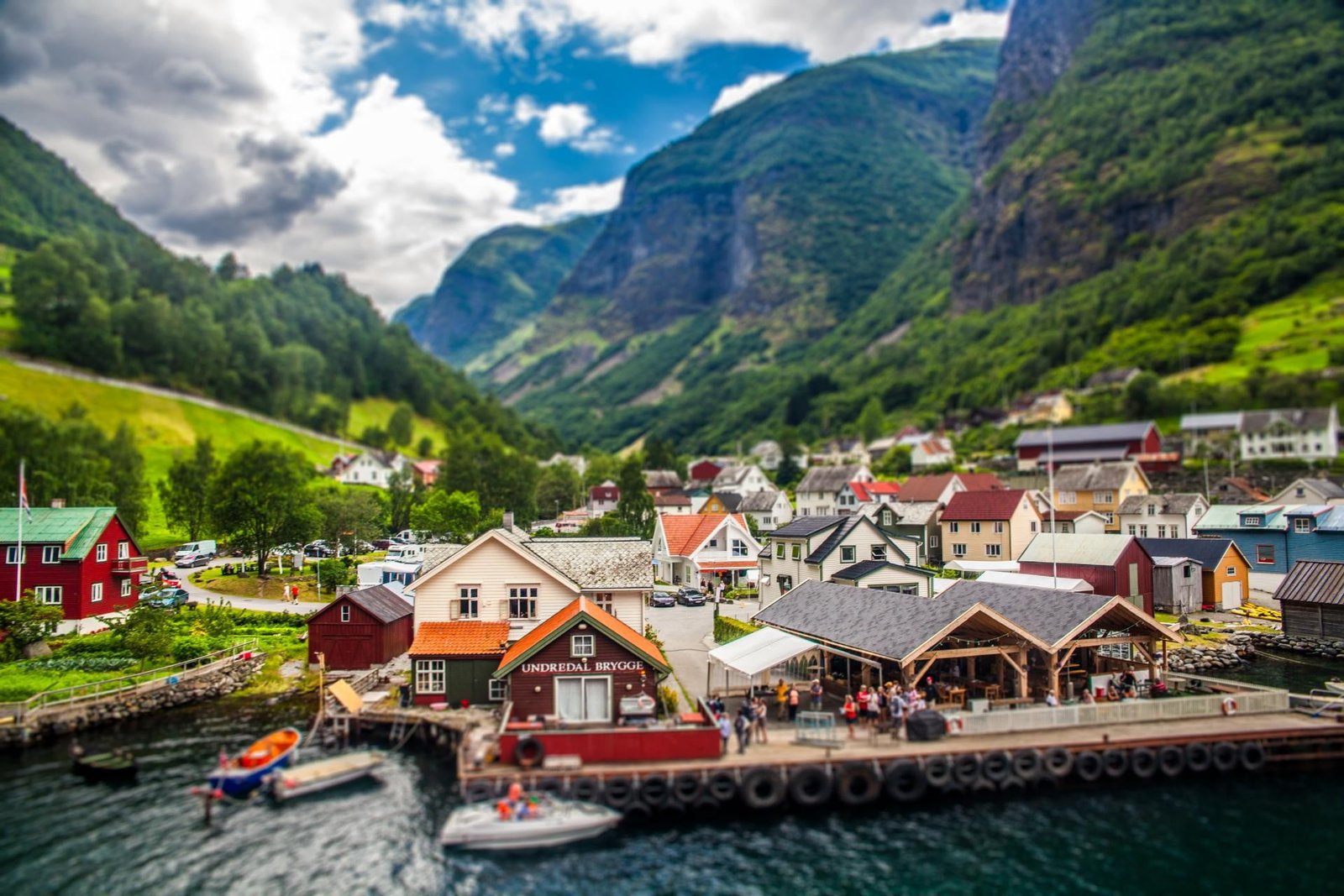 white motorboat and brown painted houses beside body of water 2k