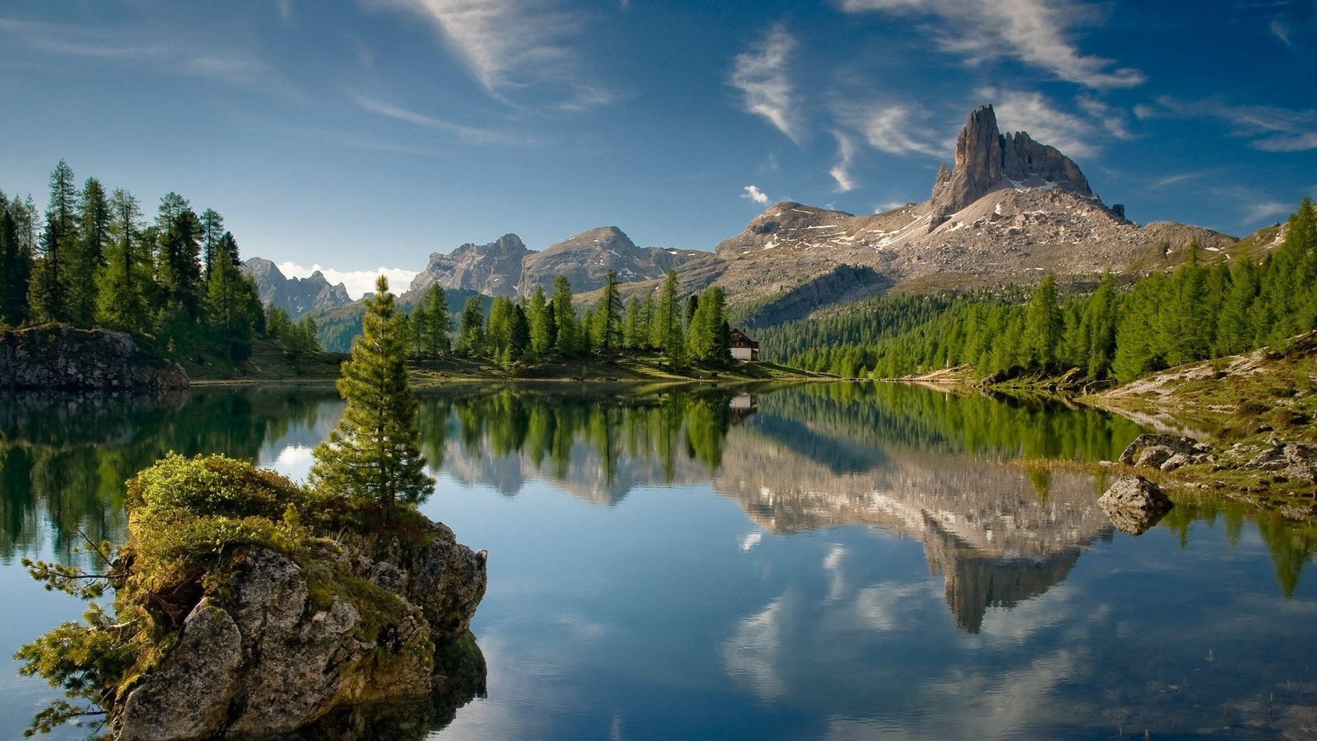 clear calm body of water surrounded by trees lake rock mountains 2k