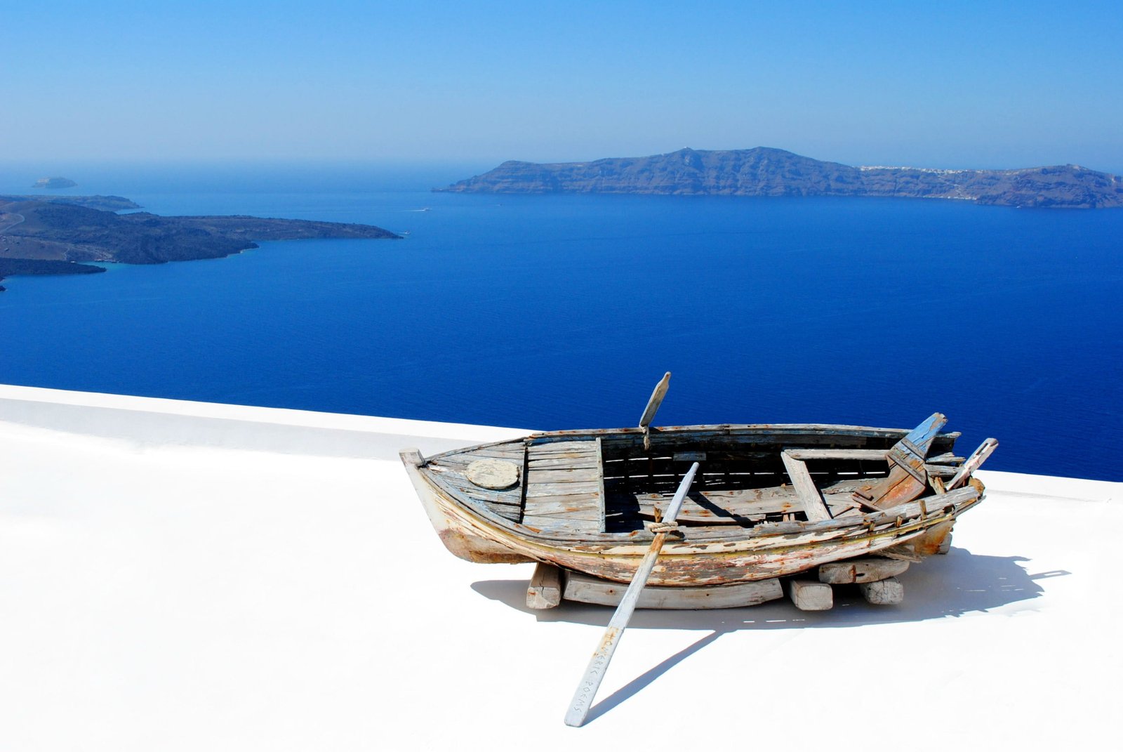 photo of beige wooden boat on top concrete floor santorini 2k