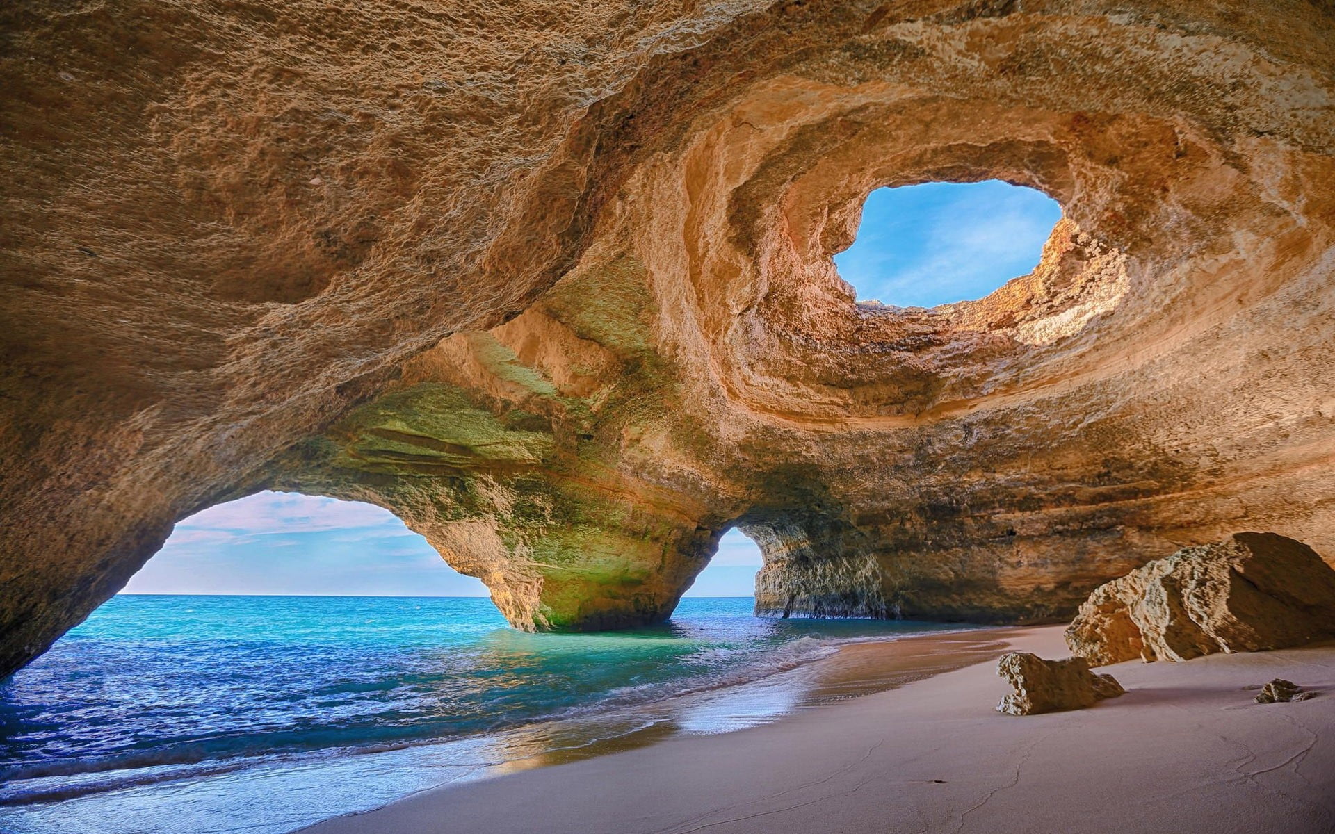 boulder and body of water Portugal cave beach rock sand 2k
