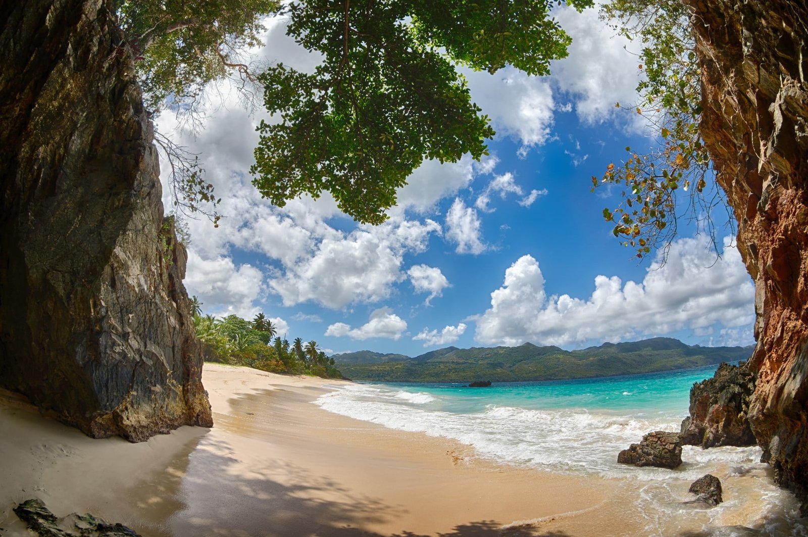 rock cave near body of water beach tropical sand mountains 2k