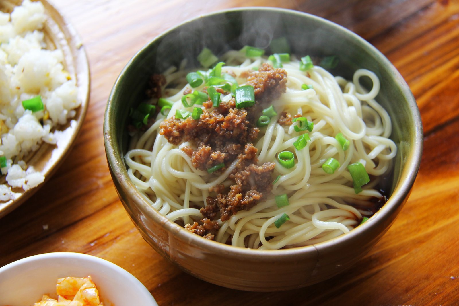 cooked noodle in gray ceramic bowl with spring onions noodles 2k