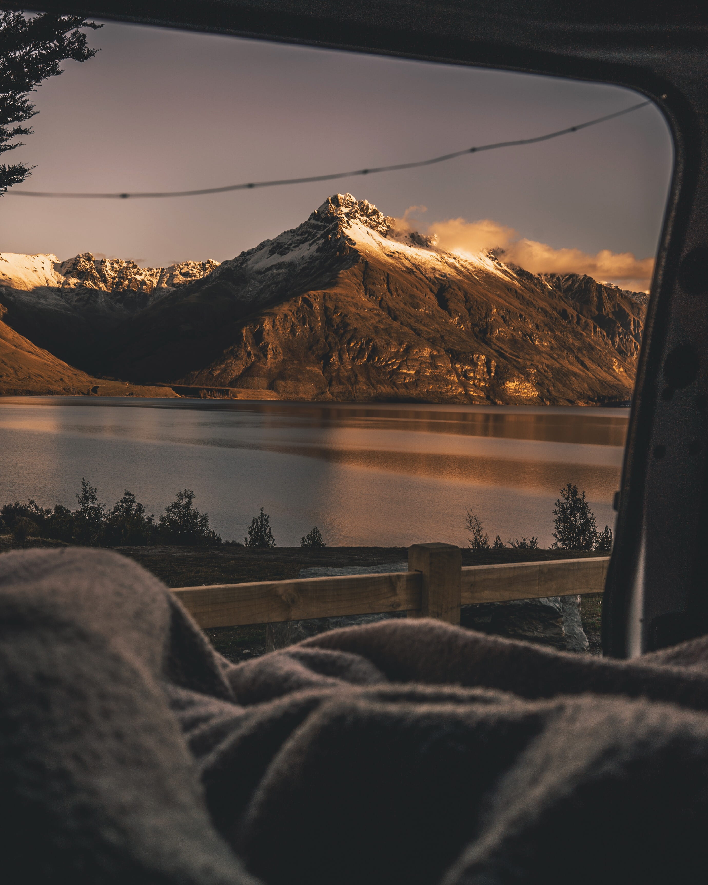 snow capped mountain beside lake view from vehicle door blanket 2k