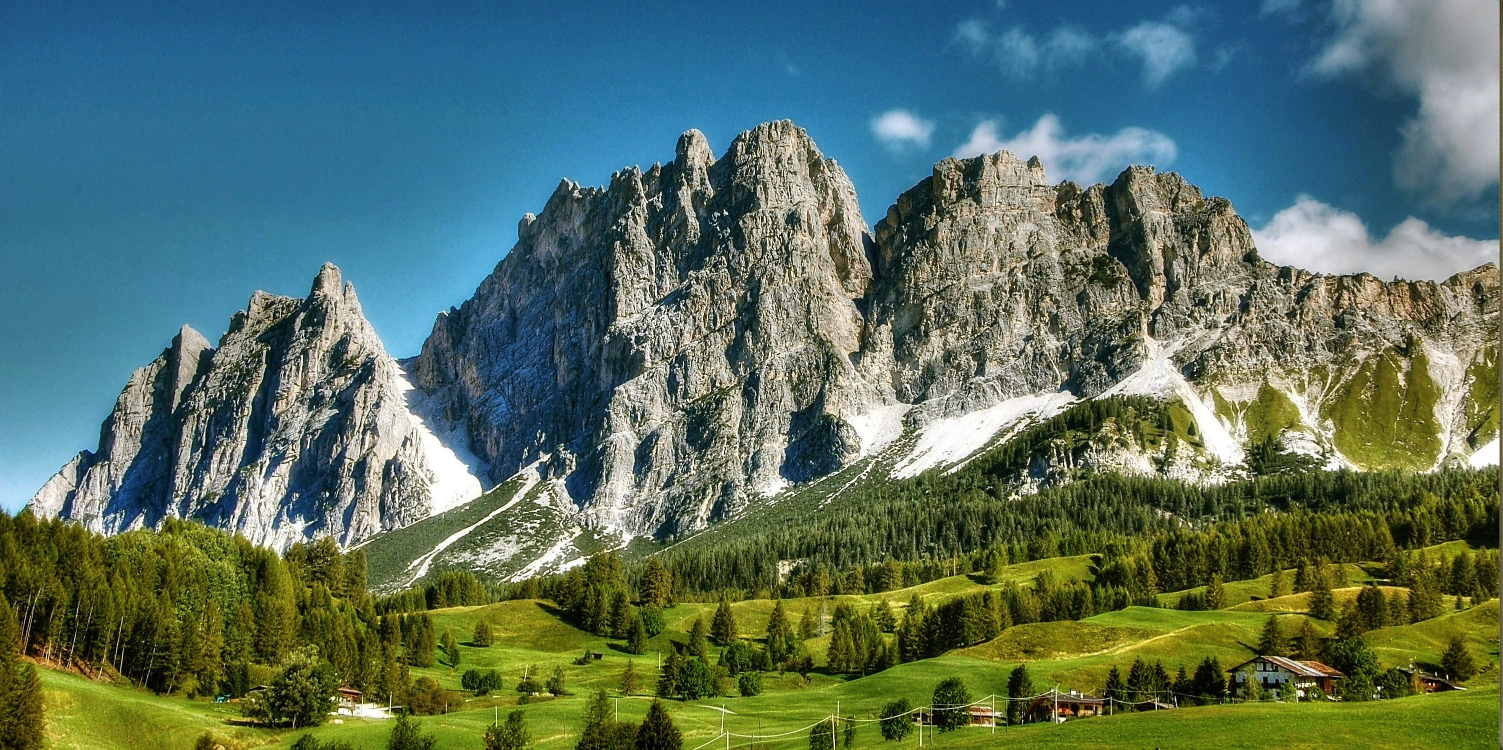 green fields and mountain during daytime rocky landscape 2k