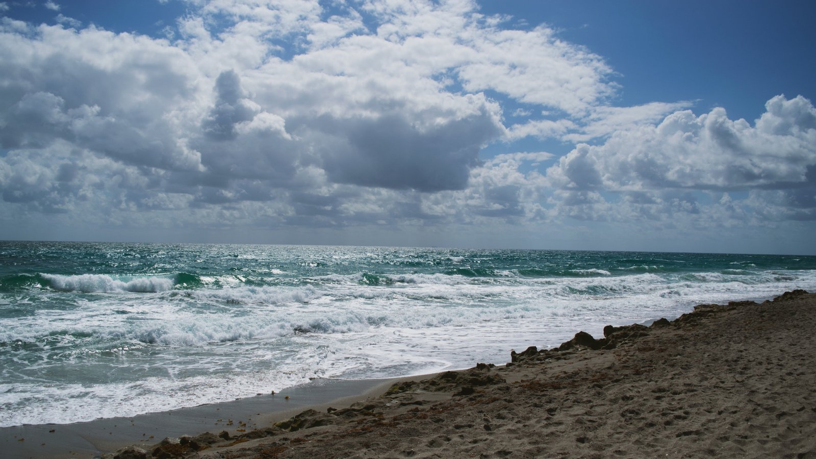 beach and thick white cloud sand sea water sky 2k 4k