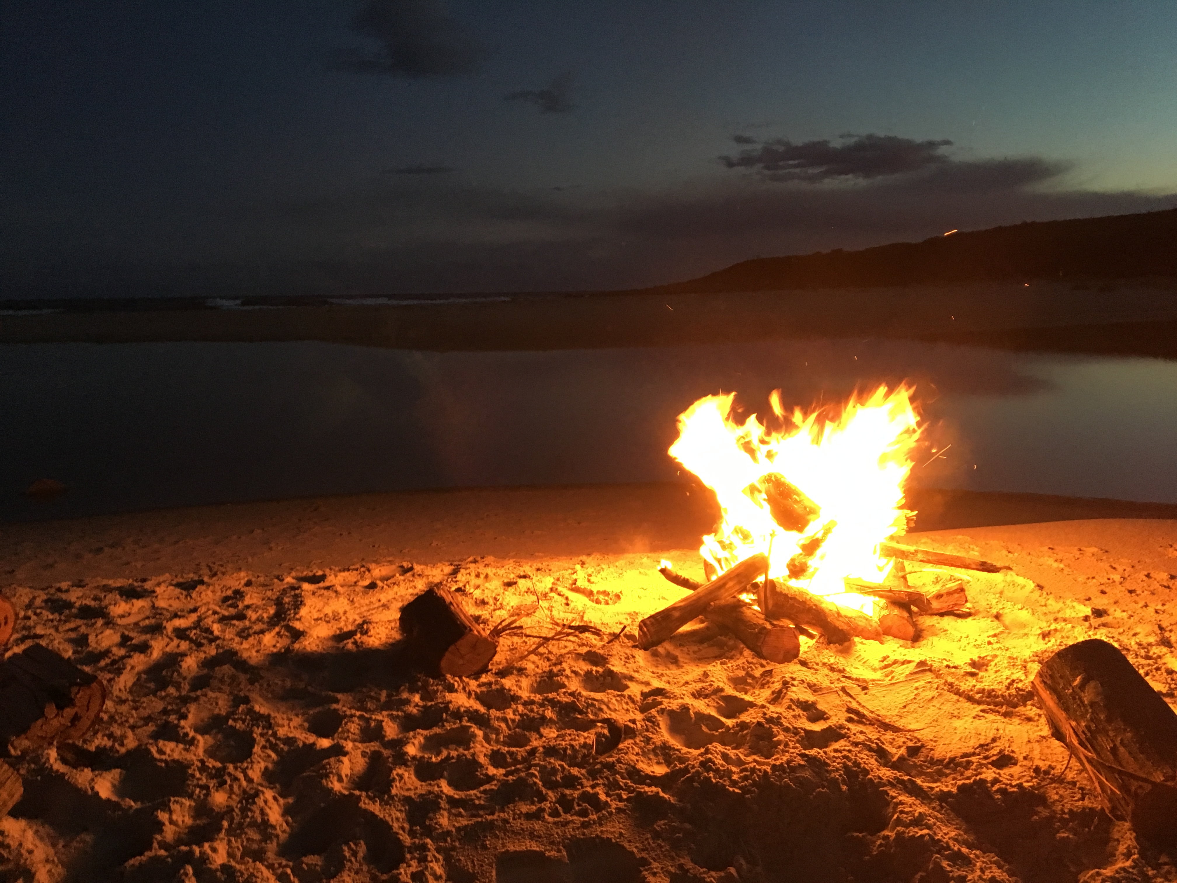 bonfire beside seashore beach coast summer flame sand wood 2k 4k