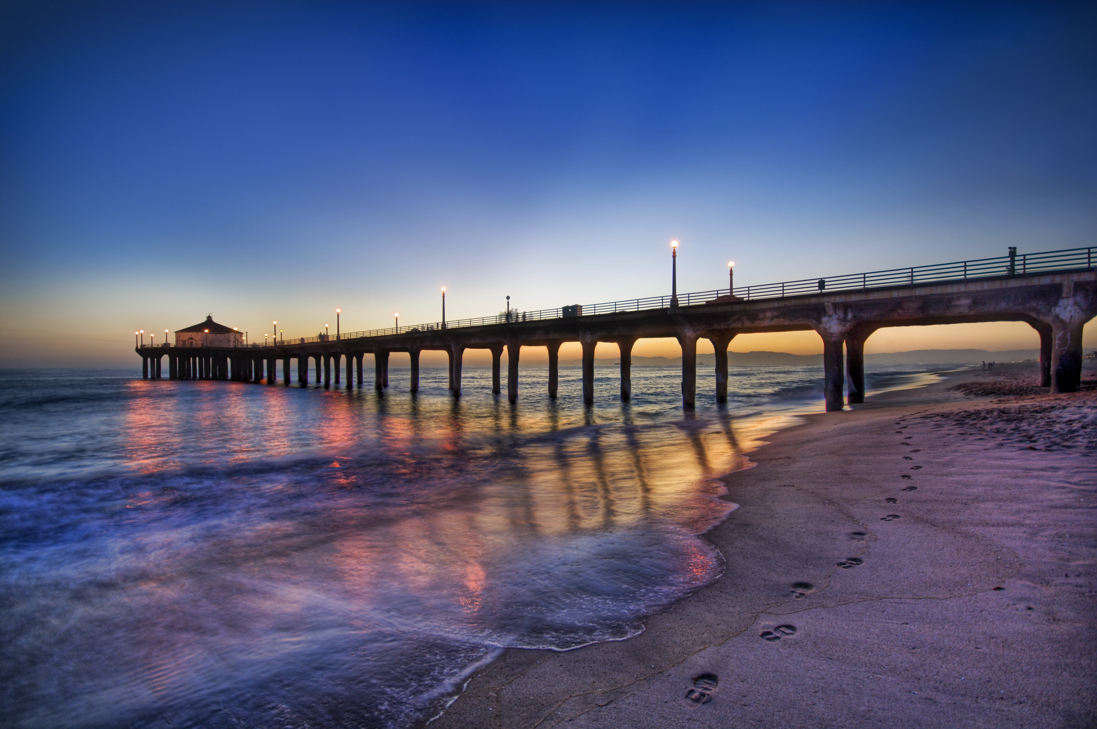 grey foot bridge beside bodies of water Footprints Blue Sunset 2k 4k