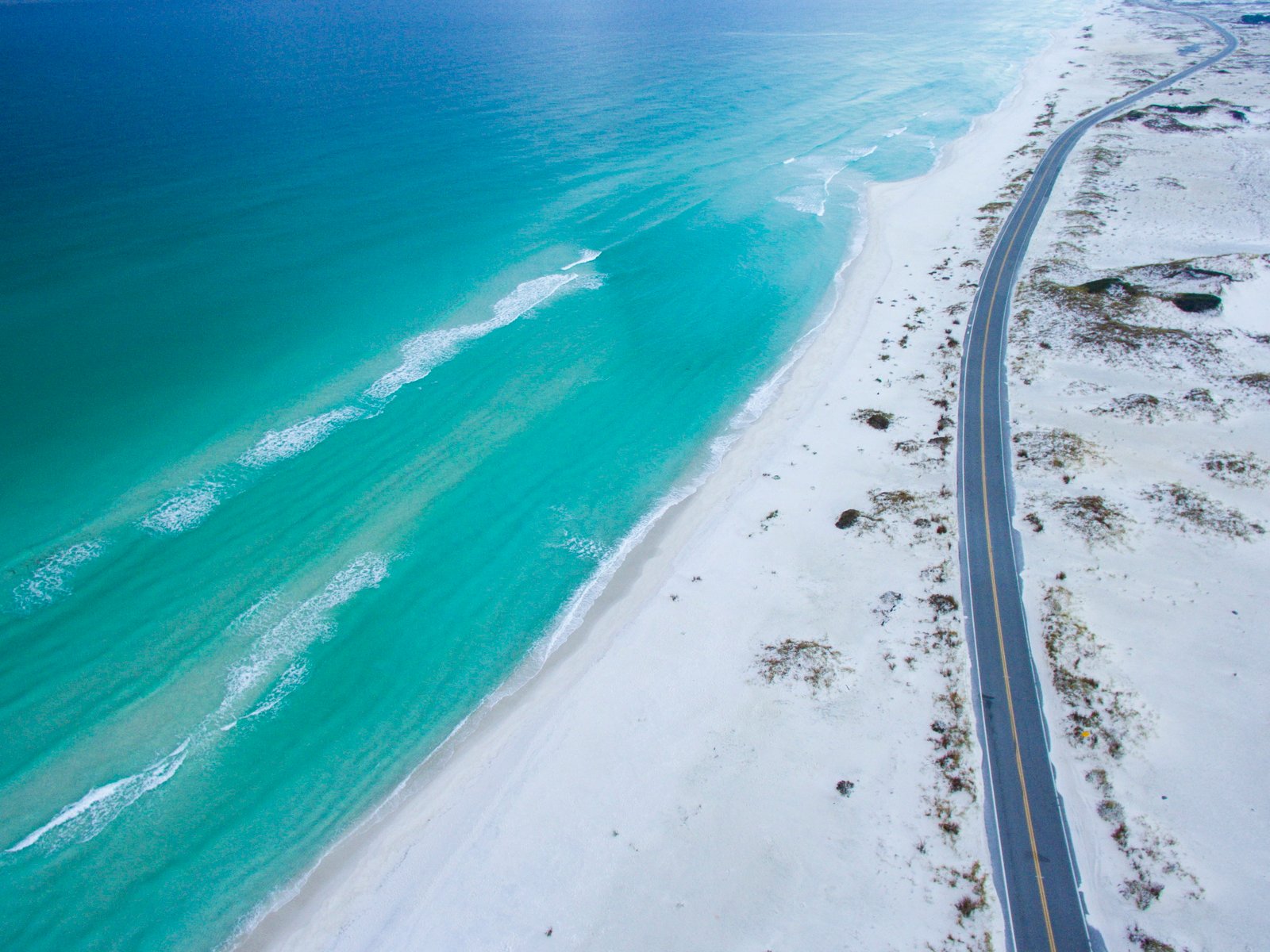 aerial photo of beach near road during daytime top view 2k 4k