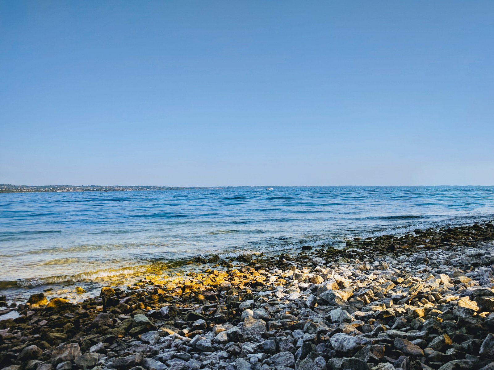 brown rocky shore beach sea water sky clear land beauty in nature 2k 4k