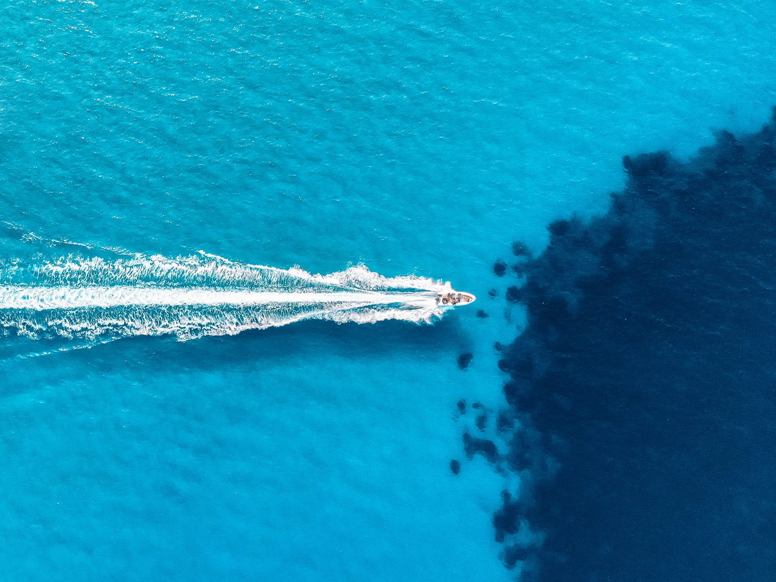 white motor boat on body of water during daytime drone view 2k