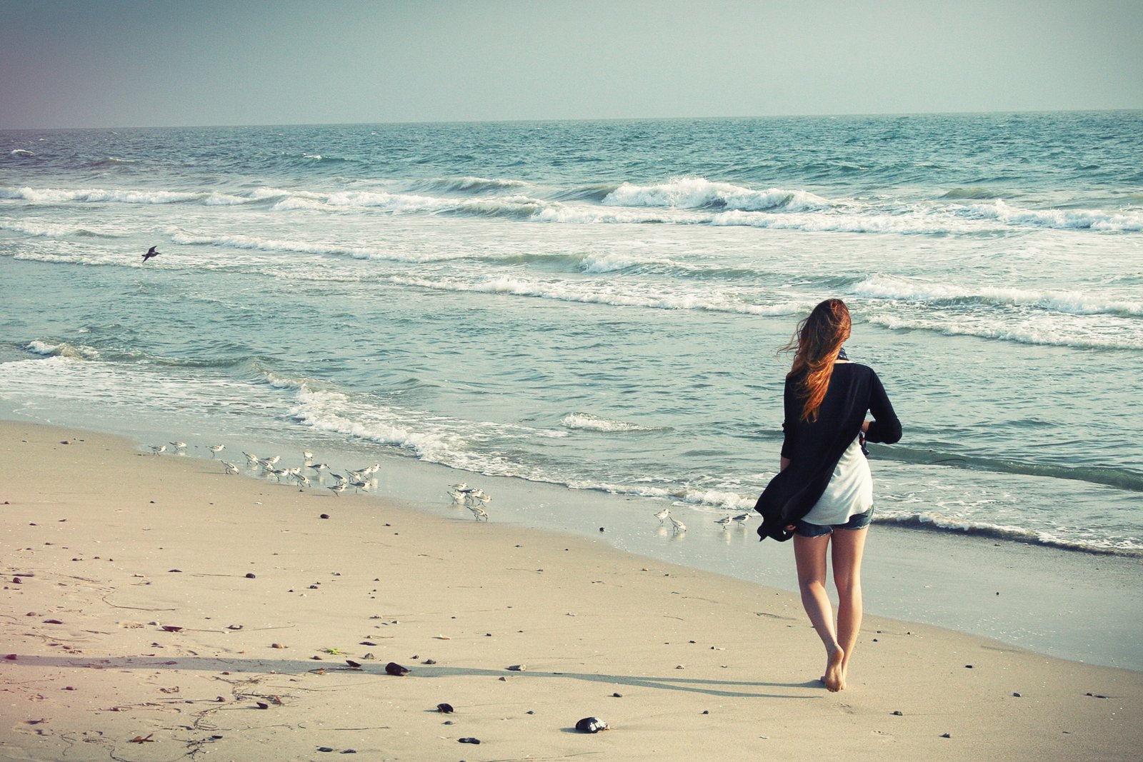 woman walking beside of beach during daytime away 2k 4k
