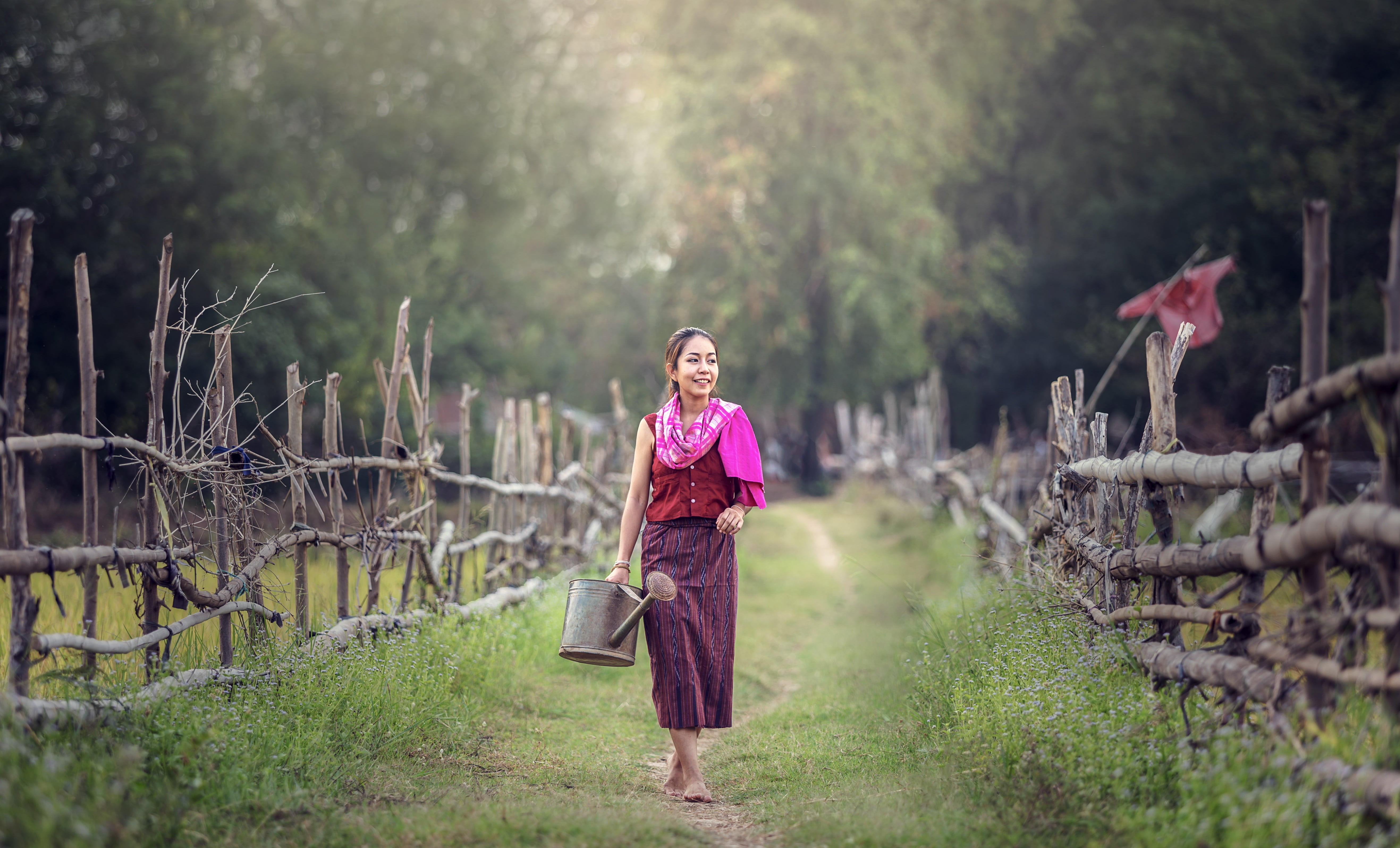woman wearing red and purple dress watering for farming smiling 2k 4k 5k