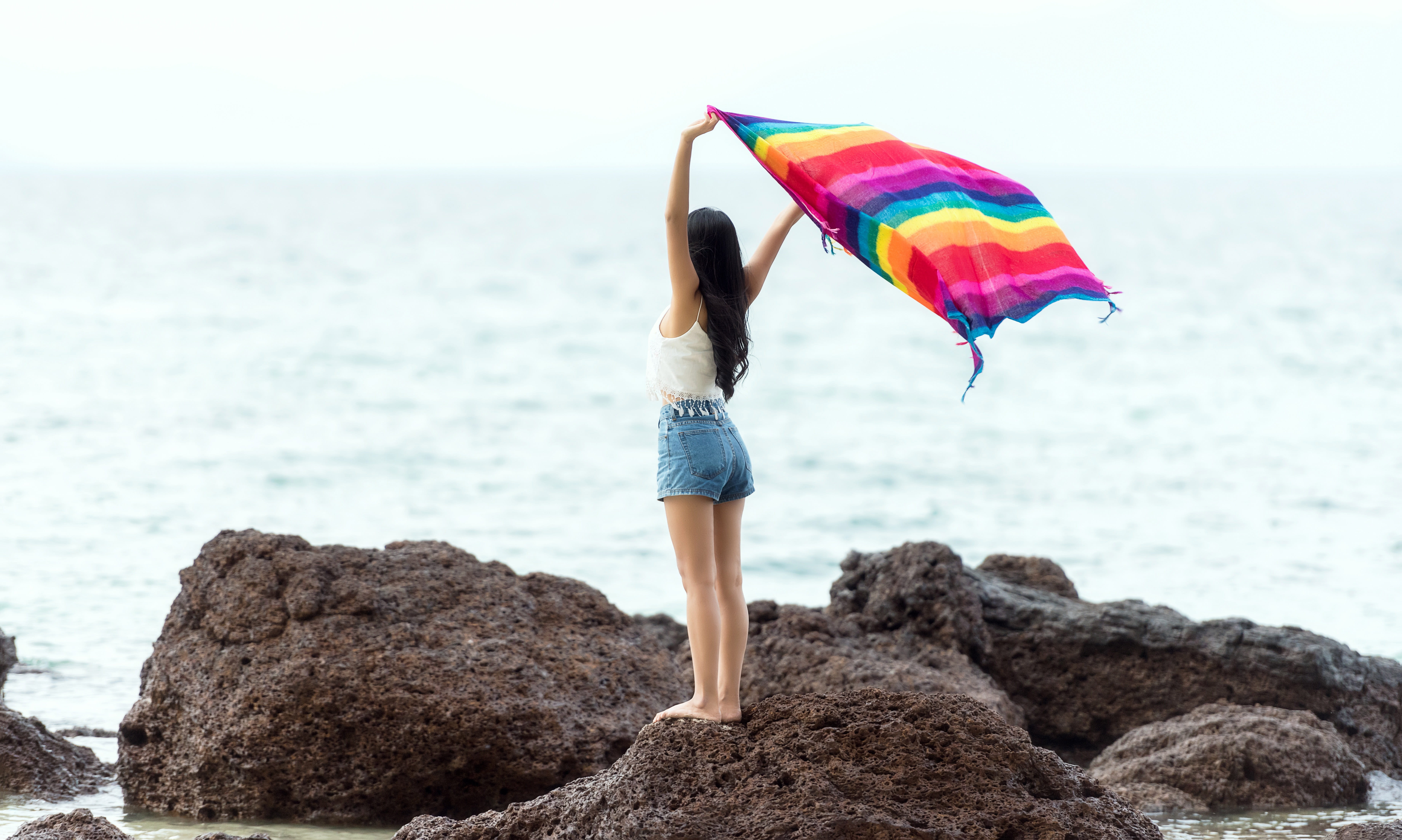 Girl standing on a rock with blanket the seashore in Maldives 2k 4k 5k