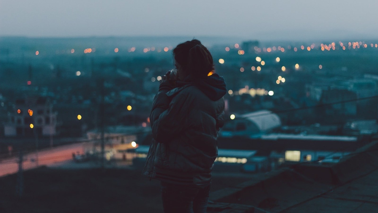 black bubble jacket with hood woman in and gray standing on a hill 2k