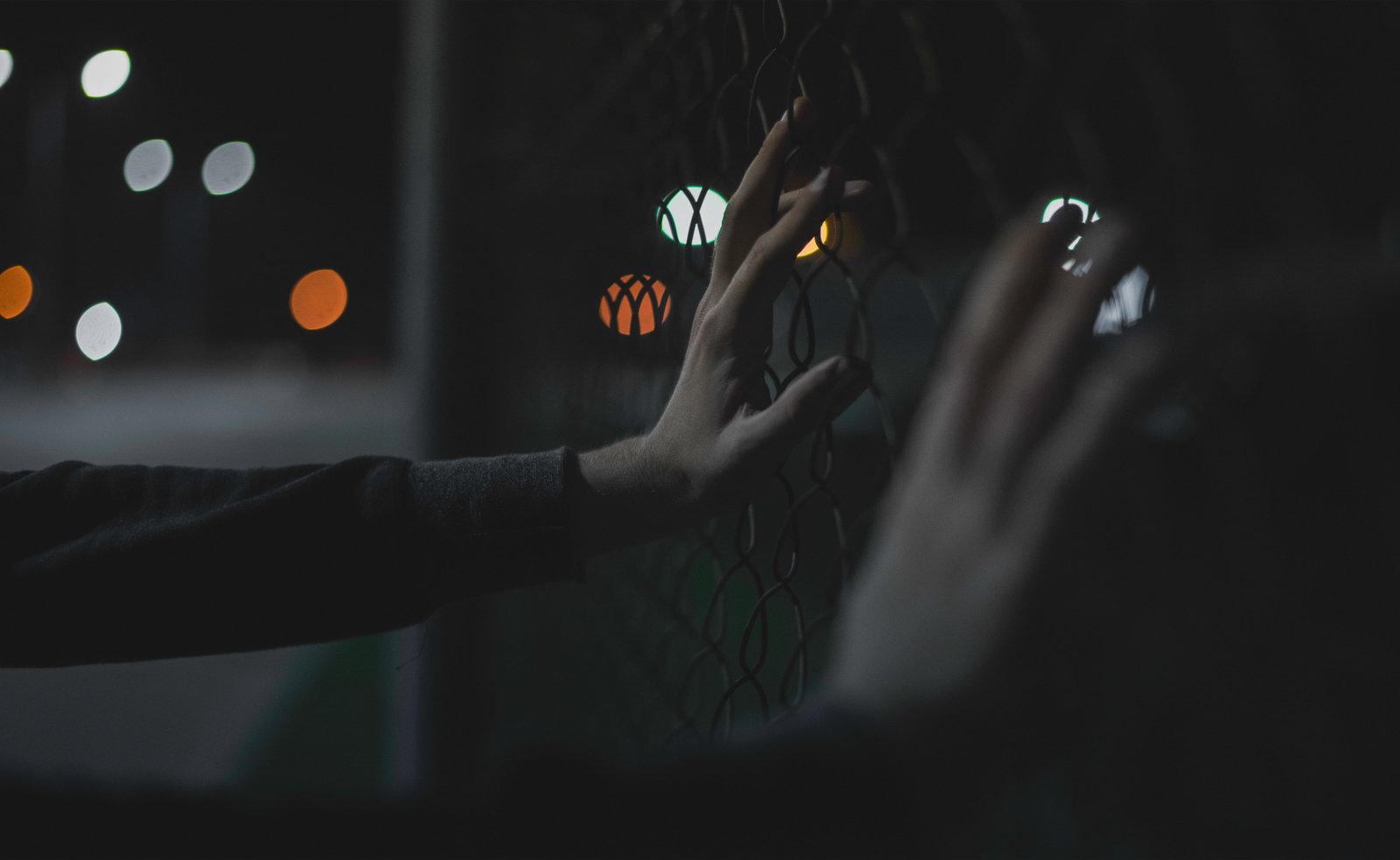 closeup photo of person s hand holding fence hands bokeh lights 2k 4k 5k