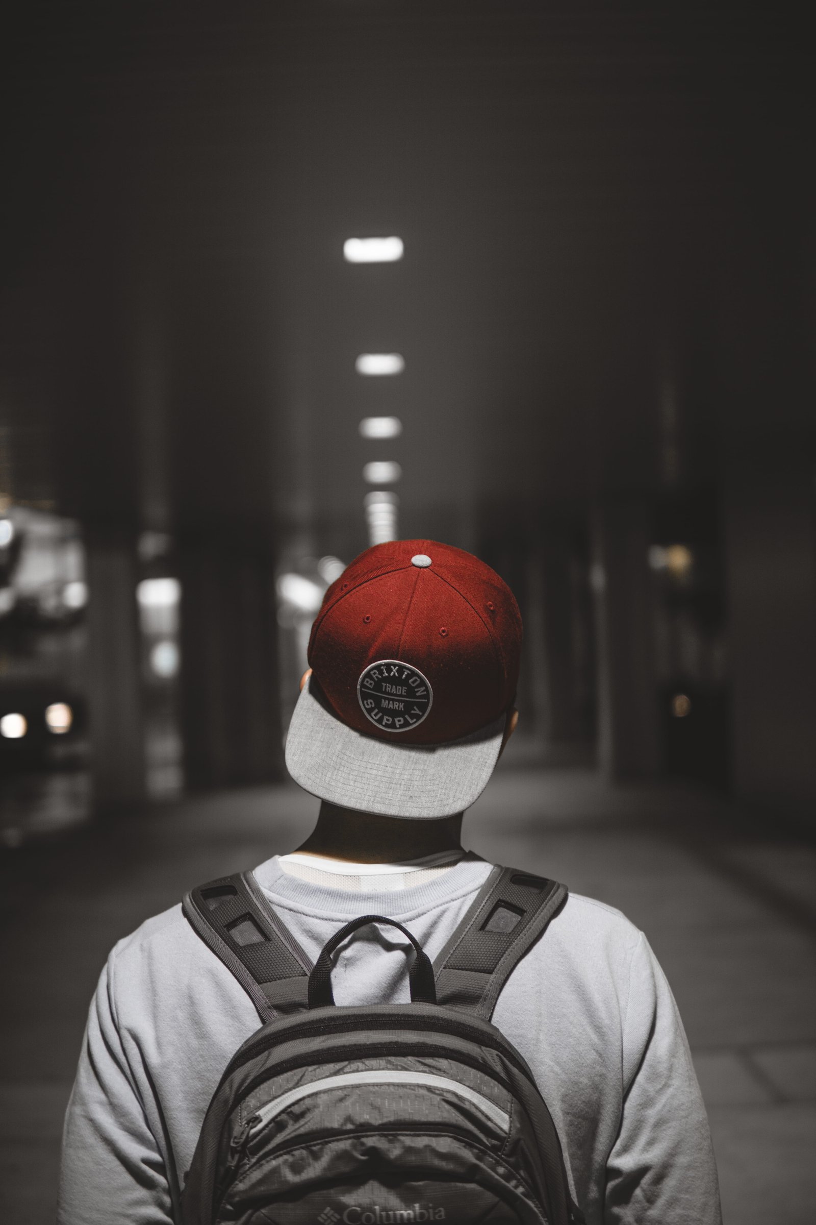 man wearing red cap facing the hallway person hat backpack 2k 4k