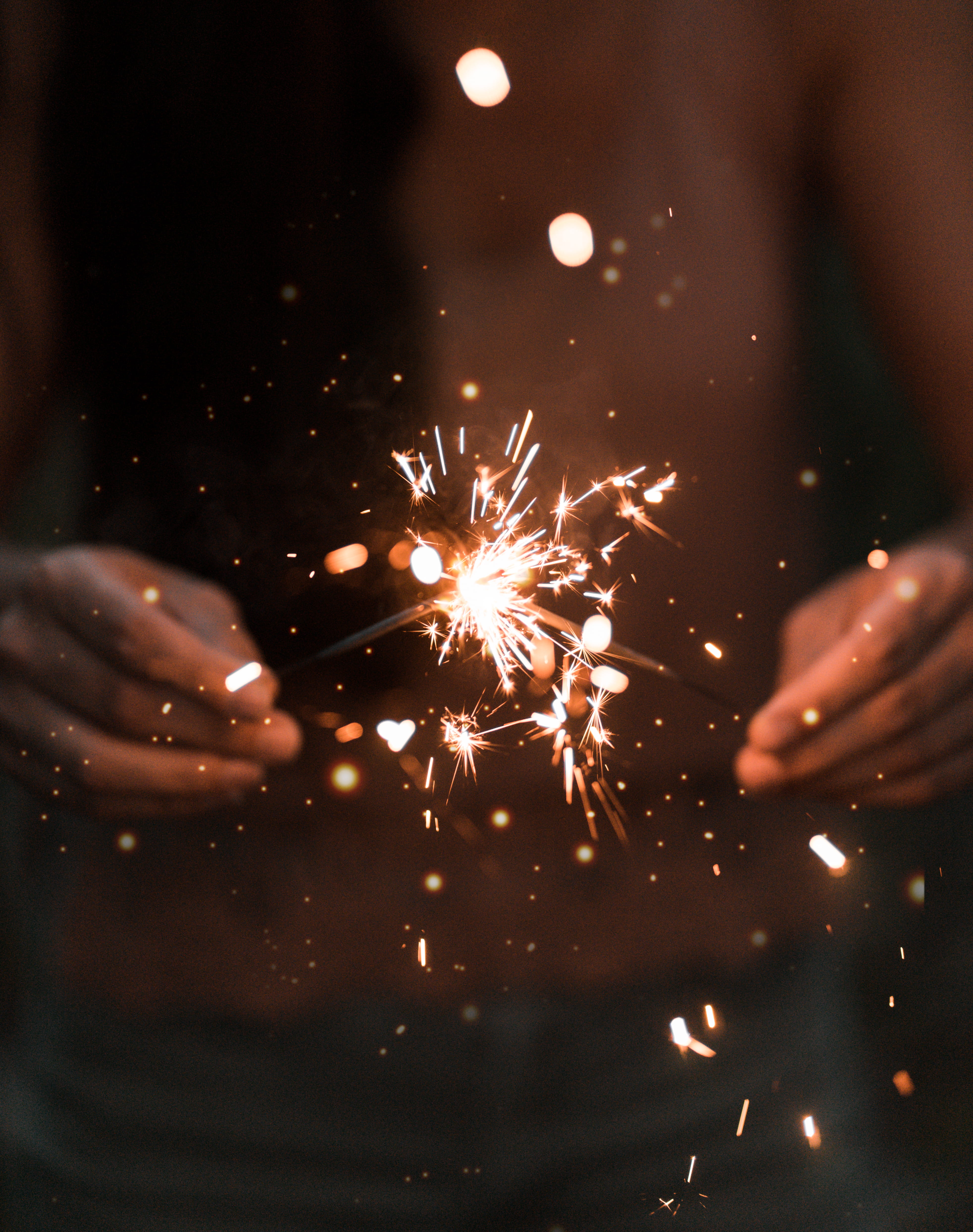 person holding fire works sparkler firework hand bokeh blur 2k 4k