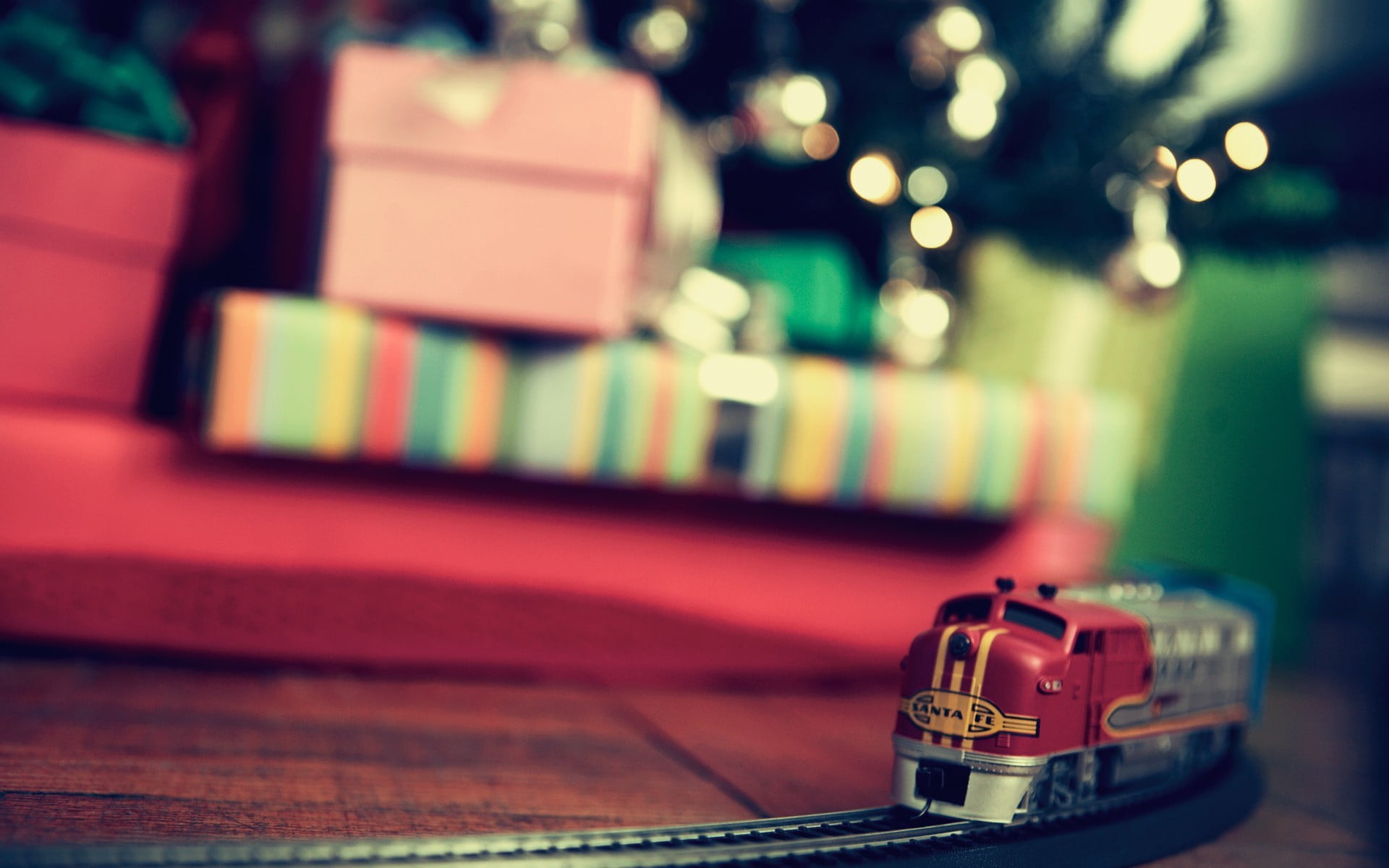 selective focus photography of red and gray train toy on brown wooden surface 2k