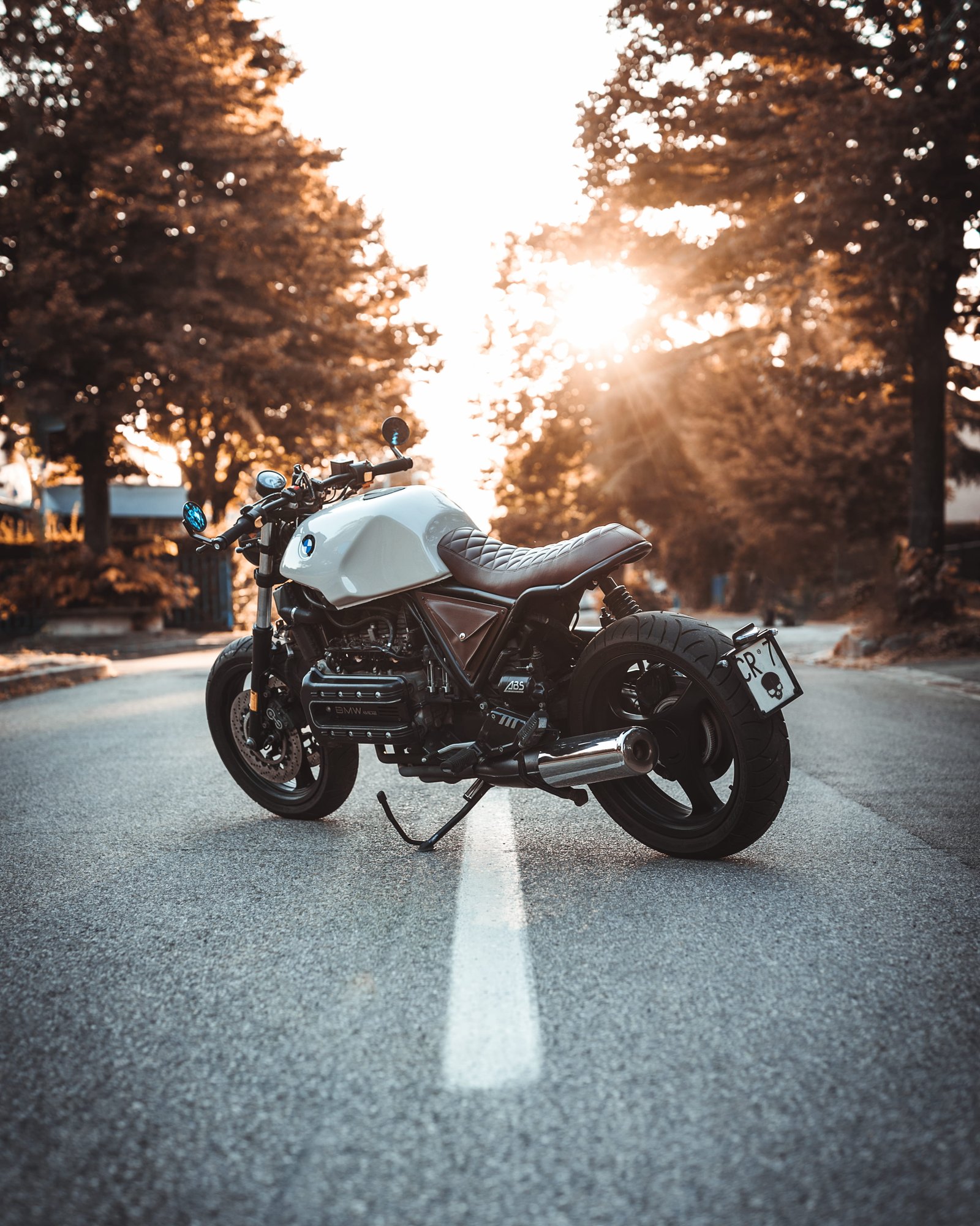 white and black BMW cruiser motorcycle in the center of road 2k 4k