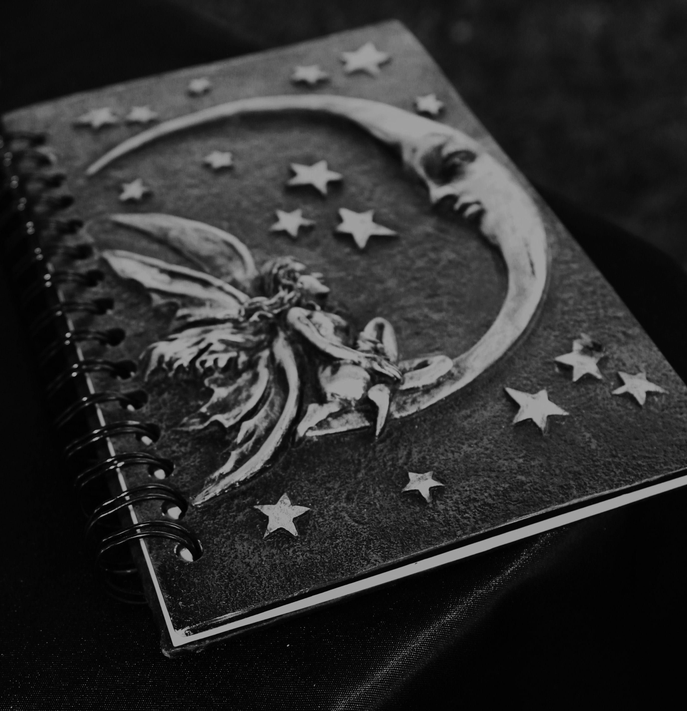 black and gray notebook with embossed crescent moon fairy design 2k