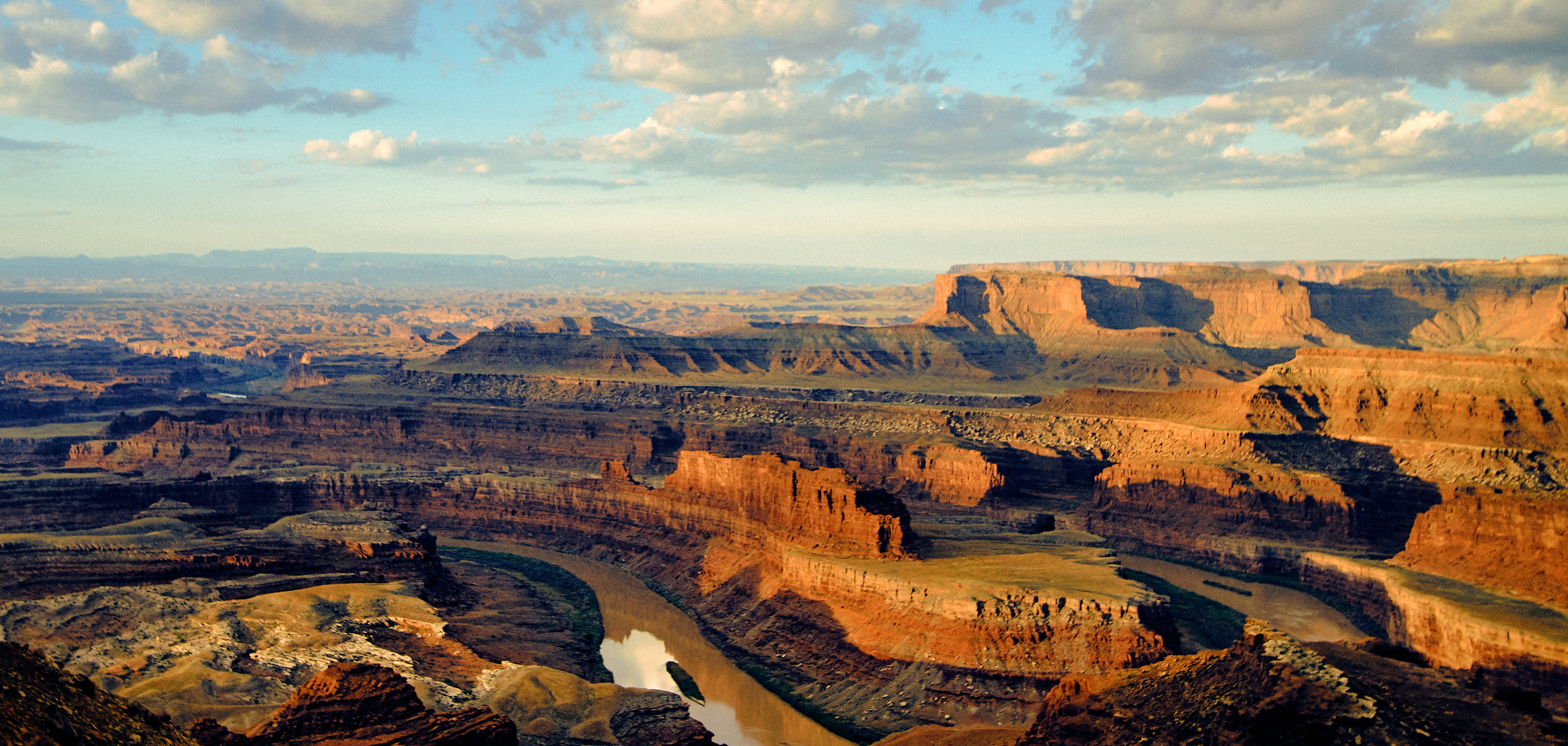 rock canyon under blue and cloudy sky during daytime Dead Horse Point State Park 2k 4k 5k