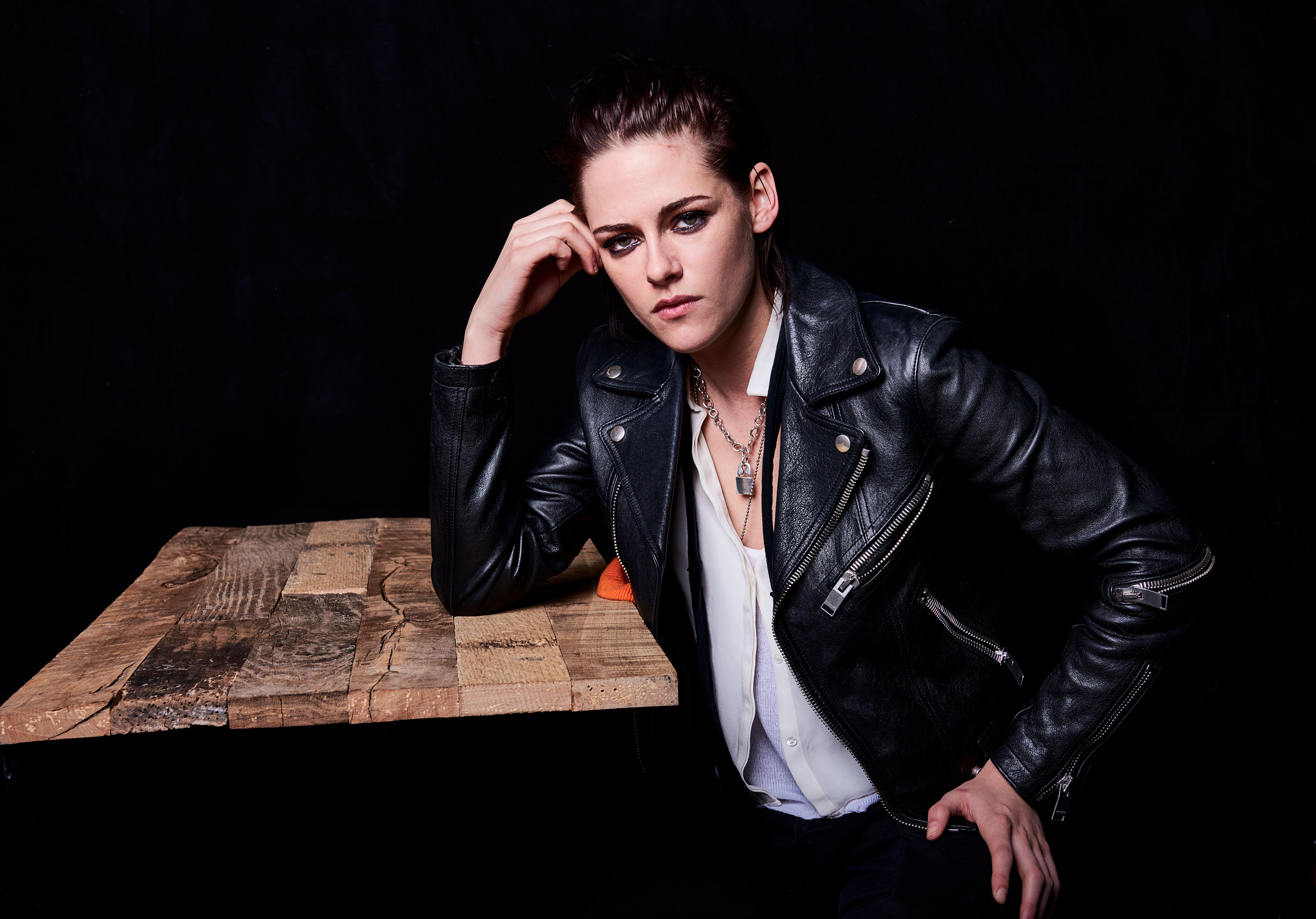 woman wearing black leather jacket leaning on brown table Kristen Stewart 2k 4k 5k 8k