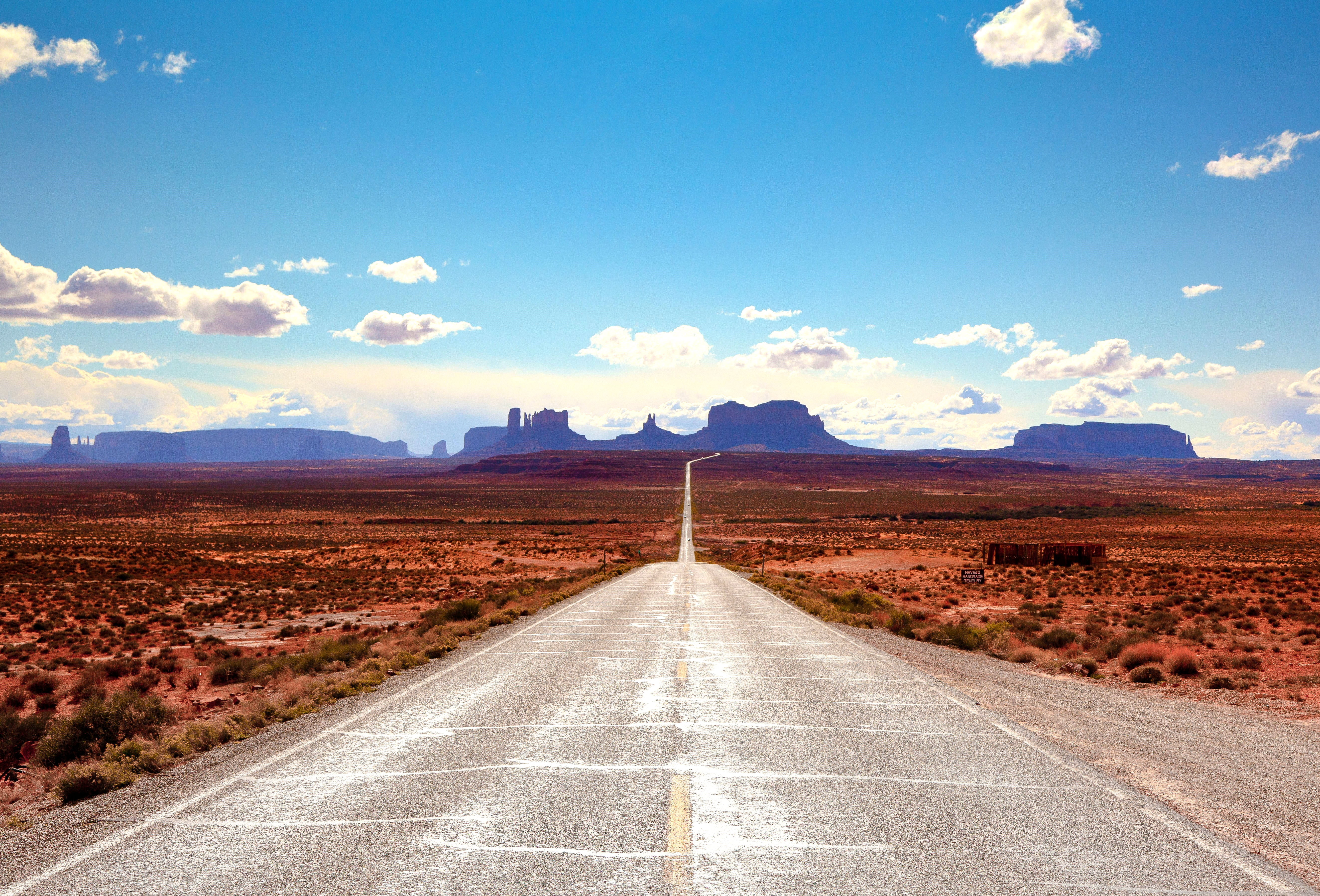 gray concrete road between brown withered grass field under blue sky 2k 4k 5k